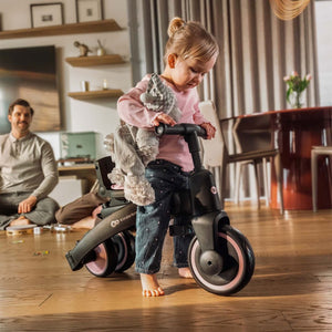 niña pequeña montada en Triciclo Multifuncional 6 en 1 Jazz 3 pink de kinderkraft en el living de su casa