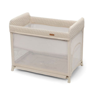 Bebé recién nacido durmiendo en cuna de viaje Moon Dream Beige con base elevada