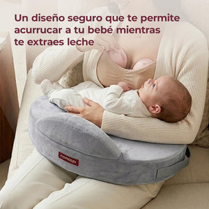 Mamá usando extractores de leche manos libres mientras acurruca a su bebé sobre un cojín de lactancia Momcozy gris
