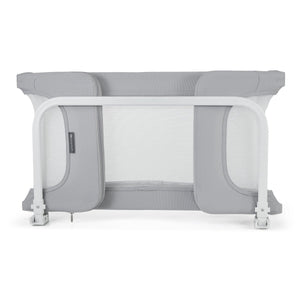 Vista frontal de barrera de cama negra rectangular con borde superior y laterales acolchados, tres paneles de malla transpirable gris clara y dos patas negras con topes antideslizantes en la base-vista plegada