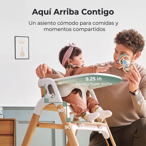 Bebé con cintillo rosado sentada en la silla DinerPal Momcozy junto a su papá, con ángulos de 90° en cadera, rodillas y tobillos y bandeja súper ancha de 9,25 pulgadas