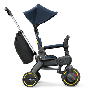 Vista lateral del Liki Trike S3 con capota extendida y barra de empuje ajustada en altura