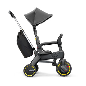 Vista lateral del Liki Trike S3 Grey Hound con capota extendida y barra de empuje ajustada