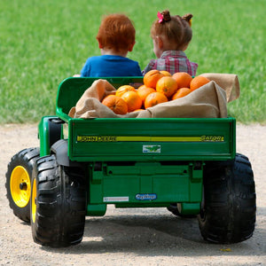 Vehículo eléctrico John Deere Gator HPX - niños conduciendo con naranjas