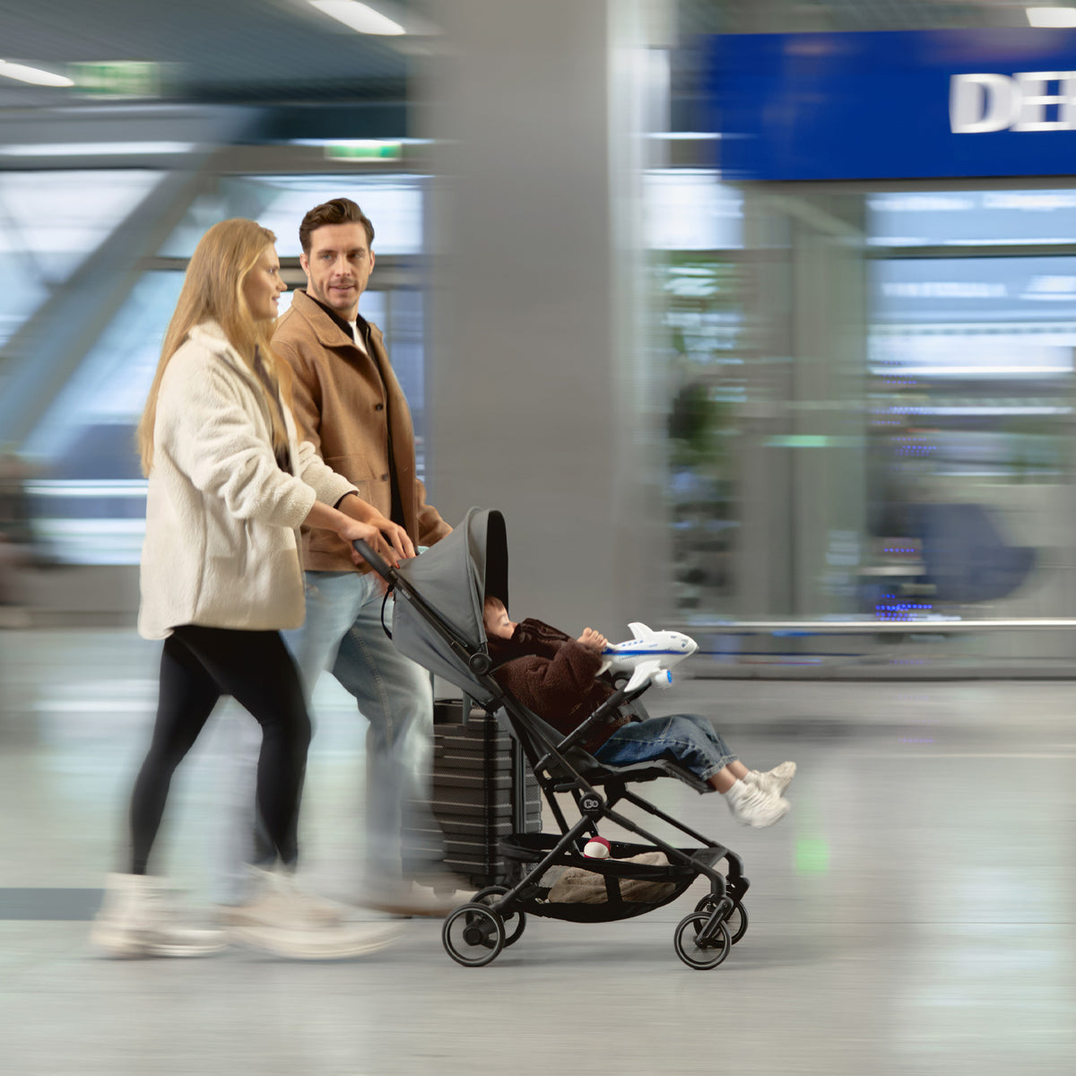 Familia en el aeropuerto con el coche de paseo de cabina Nebo Kinderkraft
