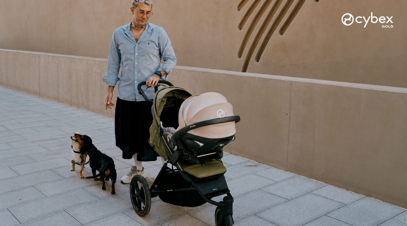hombre paseando en coche de paseo avi spin moss green de cybex y silla de auto nido