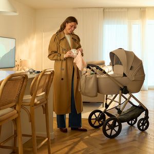 Mamá preparando el coche de su bebé mientras usa el extractor Mamaflow Kinderkraft dentro del sostén