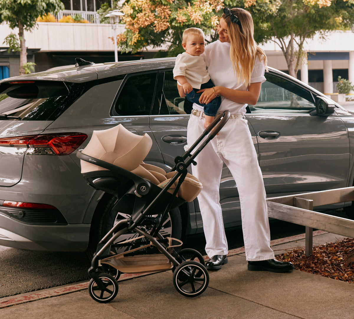 Coche de paseo eezy s twist 2 plus 2 cybex con silla de auto nido cybex en modo travel system mujer con bebé en brazos junto al auto