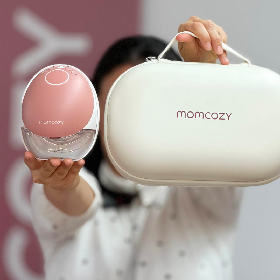 Mujer sosteniendo de frente extractor M9 de Momcozy y bolso de transpoerte