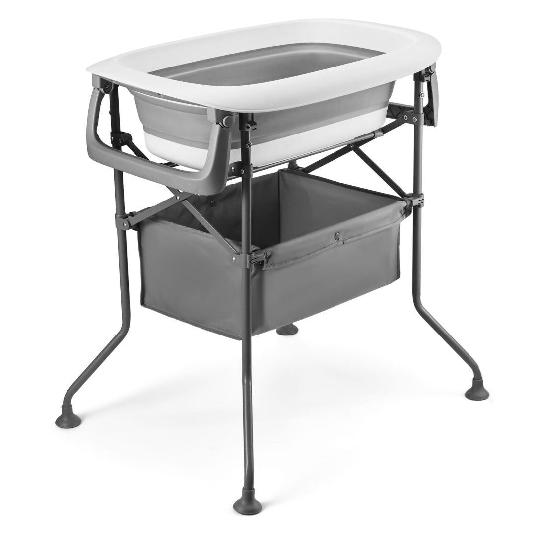 Vista angular trasera de la BUBBLY en configuración completa: mudador acolchado gris claro con estampado de estrellas y logo Kinderkraft en la parte superior, bañera blanca y gris encajada debajo, estructura metálica gris oscuro de cuatro patas con pies antideslizantes y cesta de tela gris en el nivel inferior- vista principal