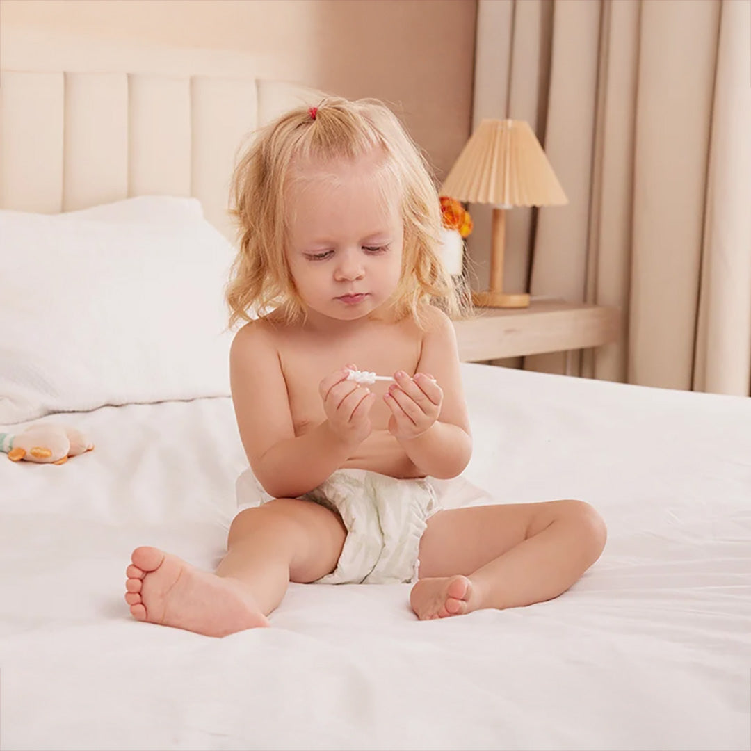 Bebé explorando el limpiador de lengua Momcozy — gasa suave y segura para el cuidado oral infantil