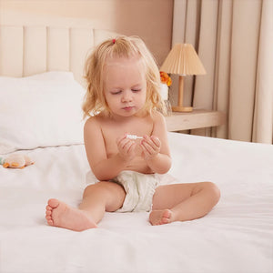 Bebé explorando el limpiador de lengua Momcozy — gasa suave y segura para el cuidado oral infantil