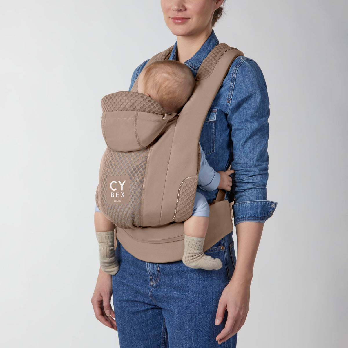 Portabebé Coÿa color Cozy Beige - vista frontal con bebé en posición frente al cuidador