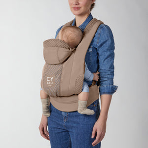 Portabebé Coÿa color Cozy Beige - vista frontal con bebé en posición frente al cuidador