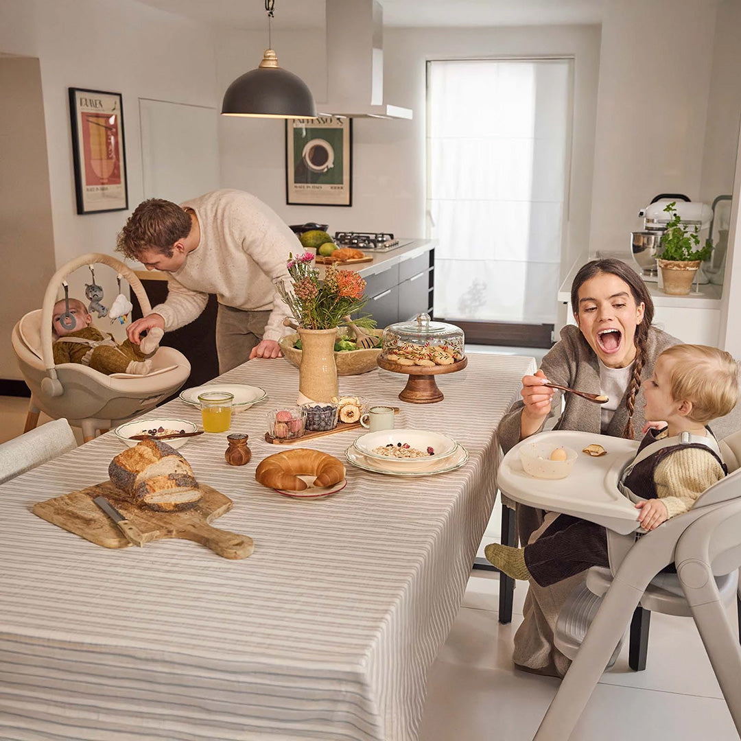Familia desayunando en la cocina con la Silla de comer 3 en 1 Tino de Kinderkraft en modo silla de comer para bebé y niño